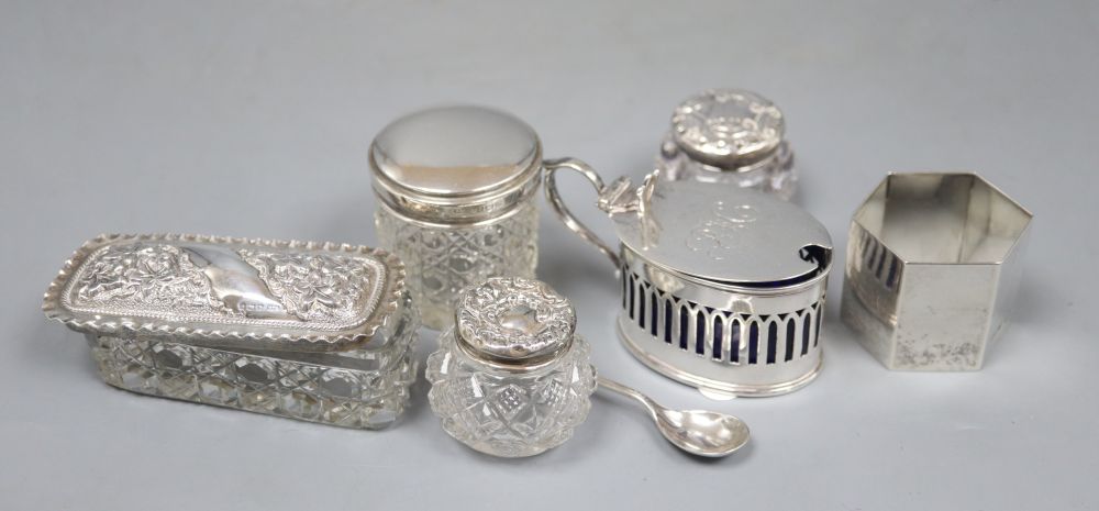 An Edwardian silver mustard pot, a silver napkin ring and four silver mounted cut glass toilet jars.